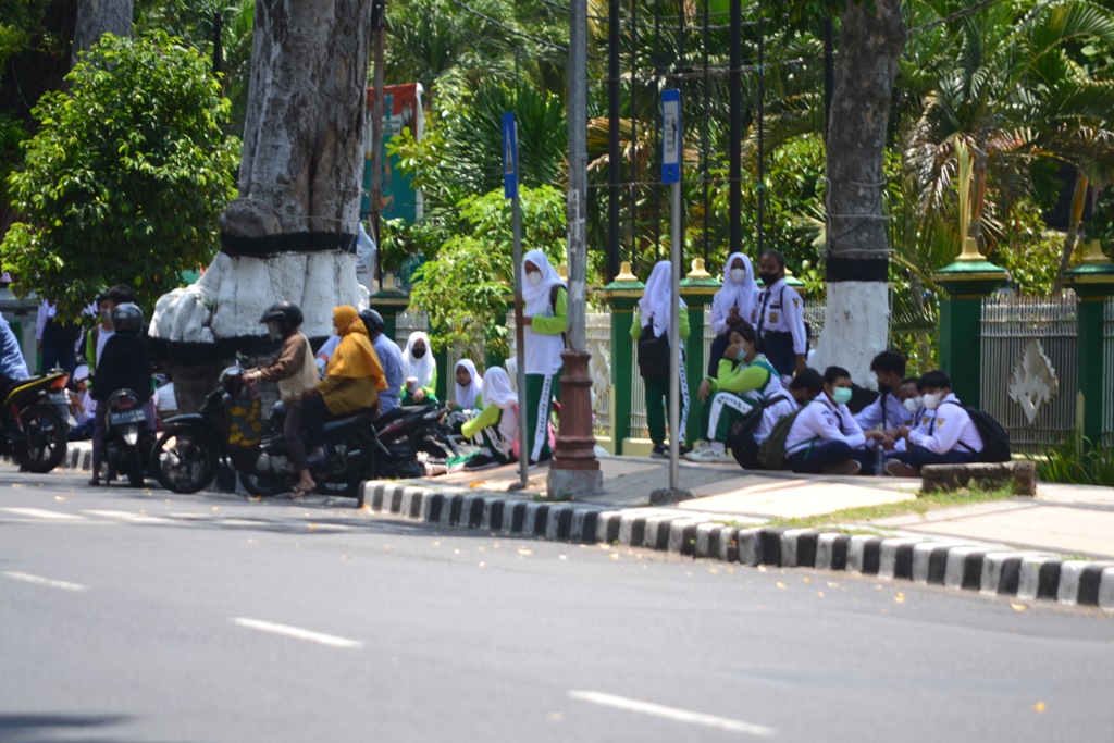MENUNGGU JEMPUTAN: Siswa sekolah tengah menunggu dijemput pulang di Jalan Pejanggik, Kota Mataram, beberapa waktu lalu.