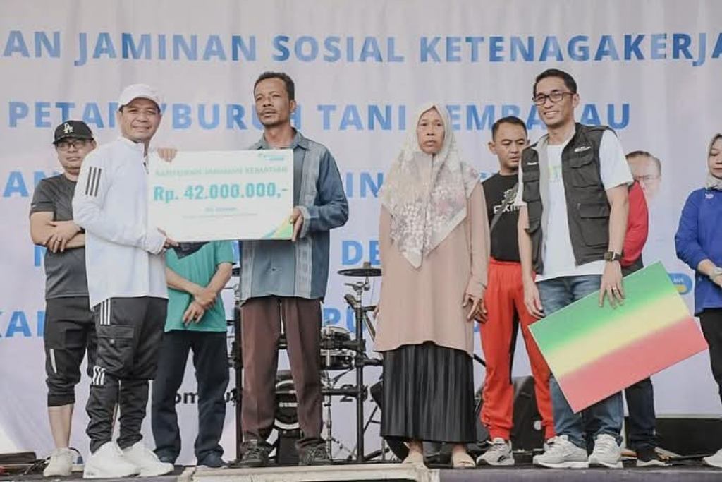 SERAHKAN BPJS: Bupati Dompu Bambang Firdaus menyerahkan secara simbolis kartu BPJS bagi para pekerja rentan, Minggu (20/4).
