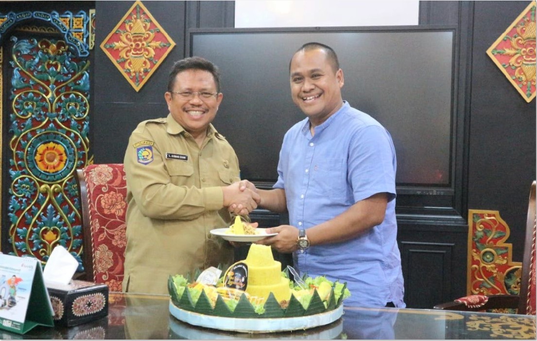 KOLABORASI: Direktur Lombok Post Alfian Yusni menyerahkan potongan tumpeng kepada Bupati Lombok Barat Lalu Ahmad Zaini sebagai ucapan selamat atas HUT Lobar ke-67, Senin (21/4).