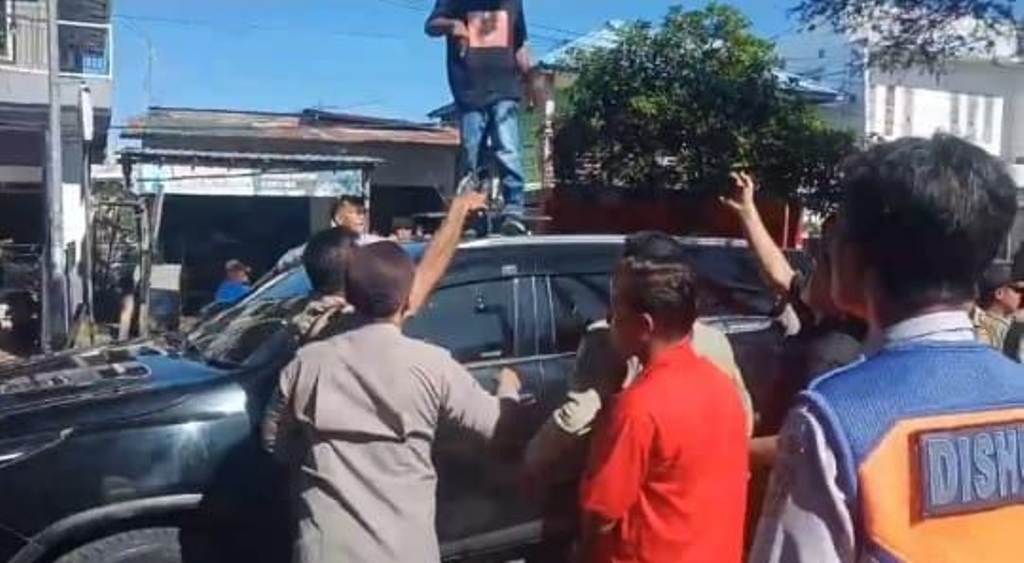 DINAIKI PENDEMO: Mobil Dinas Wabup Bima dr Irfan Zubaidy dinaiki dan dirusak para pendemo di jalan raya depan STKIP Taman Siswa, Senin (21/4).