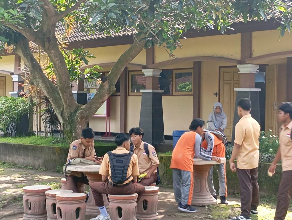 JUMLAH SISWA MENINGKAT: Sejumlah siswa SMAN 2 Narmada memanfaatkan halaman sekolah yang rindang untuk istirahat, belum lama ini. Jumlah siswa baru di sekolah ini terus meningkat.