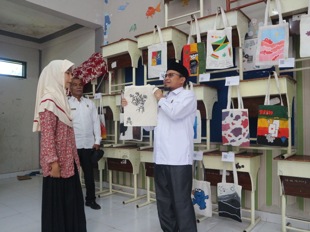 BERKELAS: Kepala Dinas Pendidikan dan Kebudayaan (Dikbud) Lombok Timur (Lotim) saat melihat pameran lukisan di SMPN 1 Selong, Rabu (23/4).