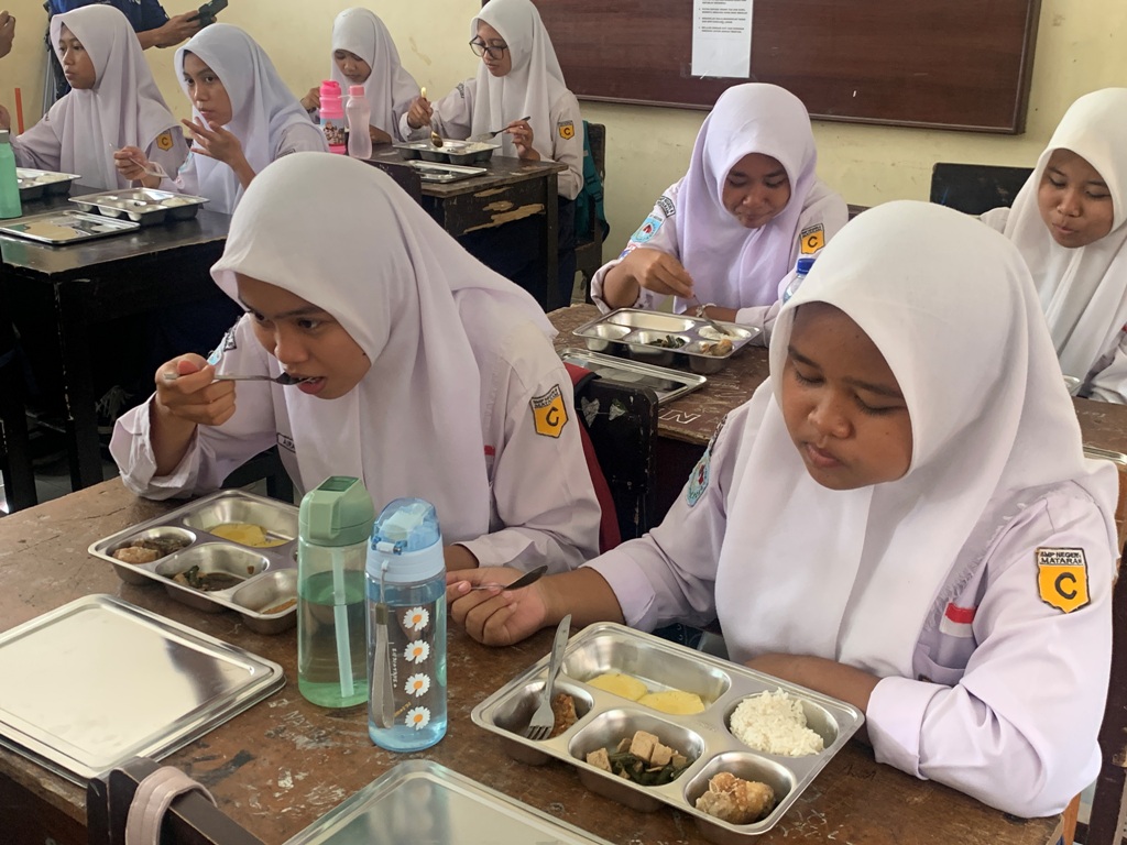 MAKAN GRATIS: Pelajar SMPN 8 Kota Mataram saat menyantap makan bergizi gratis beberapa waktu lalu.&nbsp;