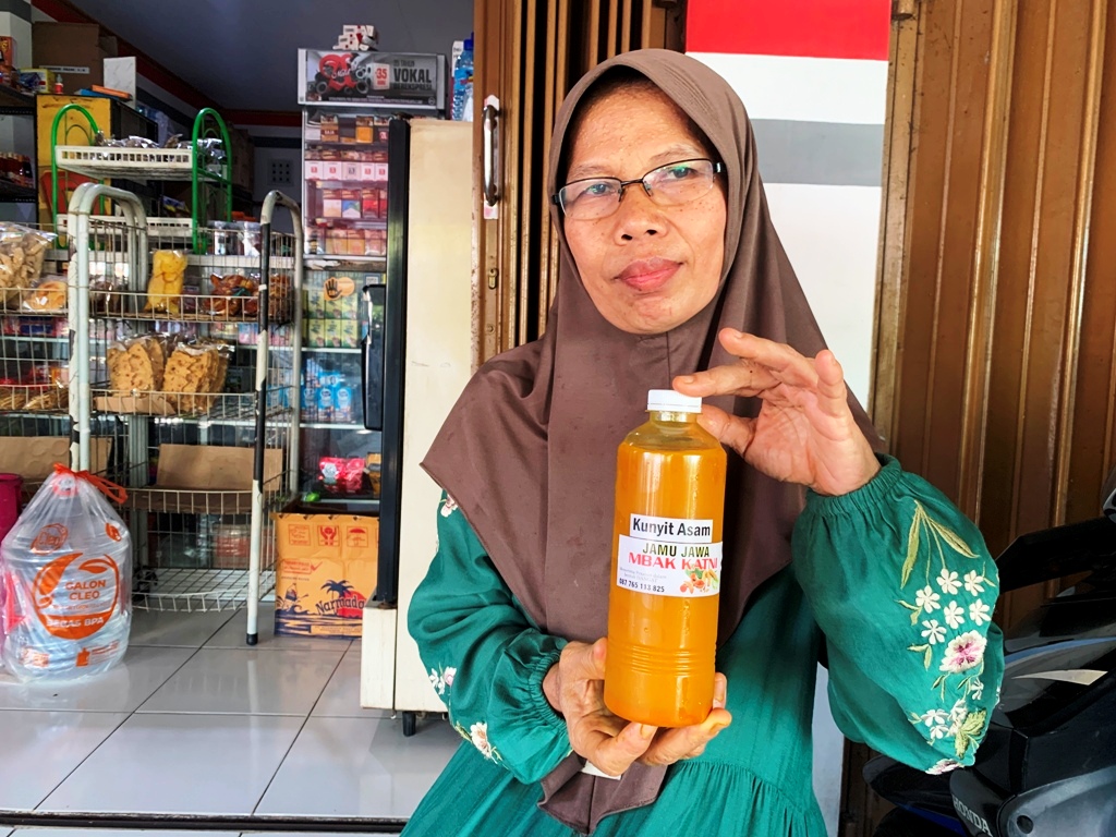 MENYEHATKAN: Sukatni menunjukkan sebotol jamu racikan yang dijualnya, belum lama ini.