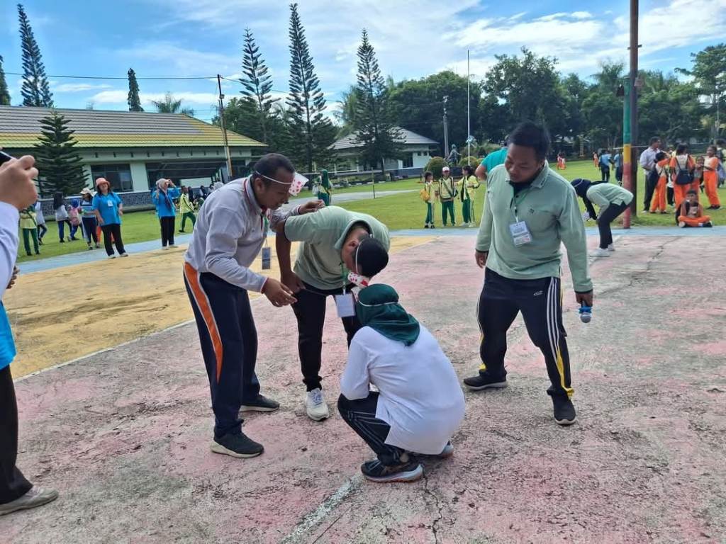 BANGUN KEBERSAMAAN : Para guru Gugus V Cakranegara mengikuti lomba memasukkan bola pimpong ke dalam gelas memeriahkan Hardiknas di Lapangan Batalyon Kompi C Gebang, Kamis lalu (1/5).