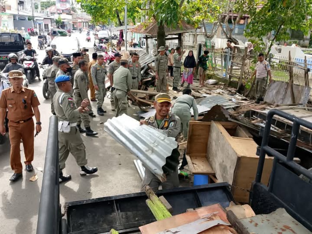 Satpol PP Dompu menertibkan lapak dagangan yang berjuanganbdi atas trotoar, belum lama ini.