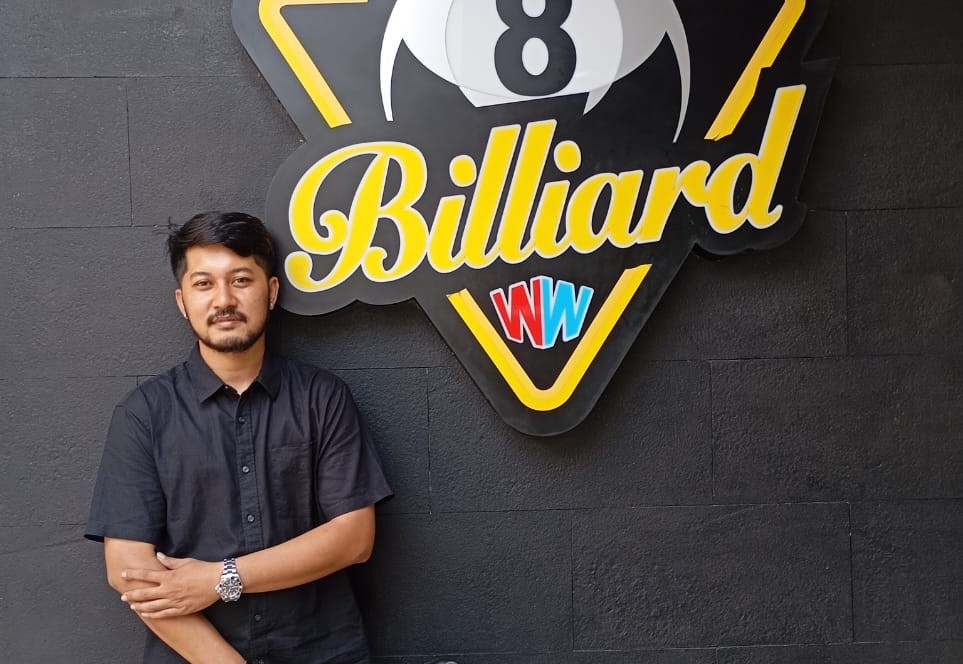 Gde Nitya Premananda, owner WW Billiard foto di depan plang rumah billiard miliknya di Jalan Guru Bangkol, Pagesangan, Kamis lalu (1/5).