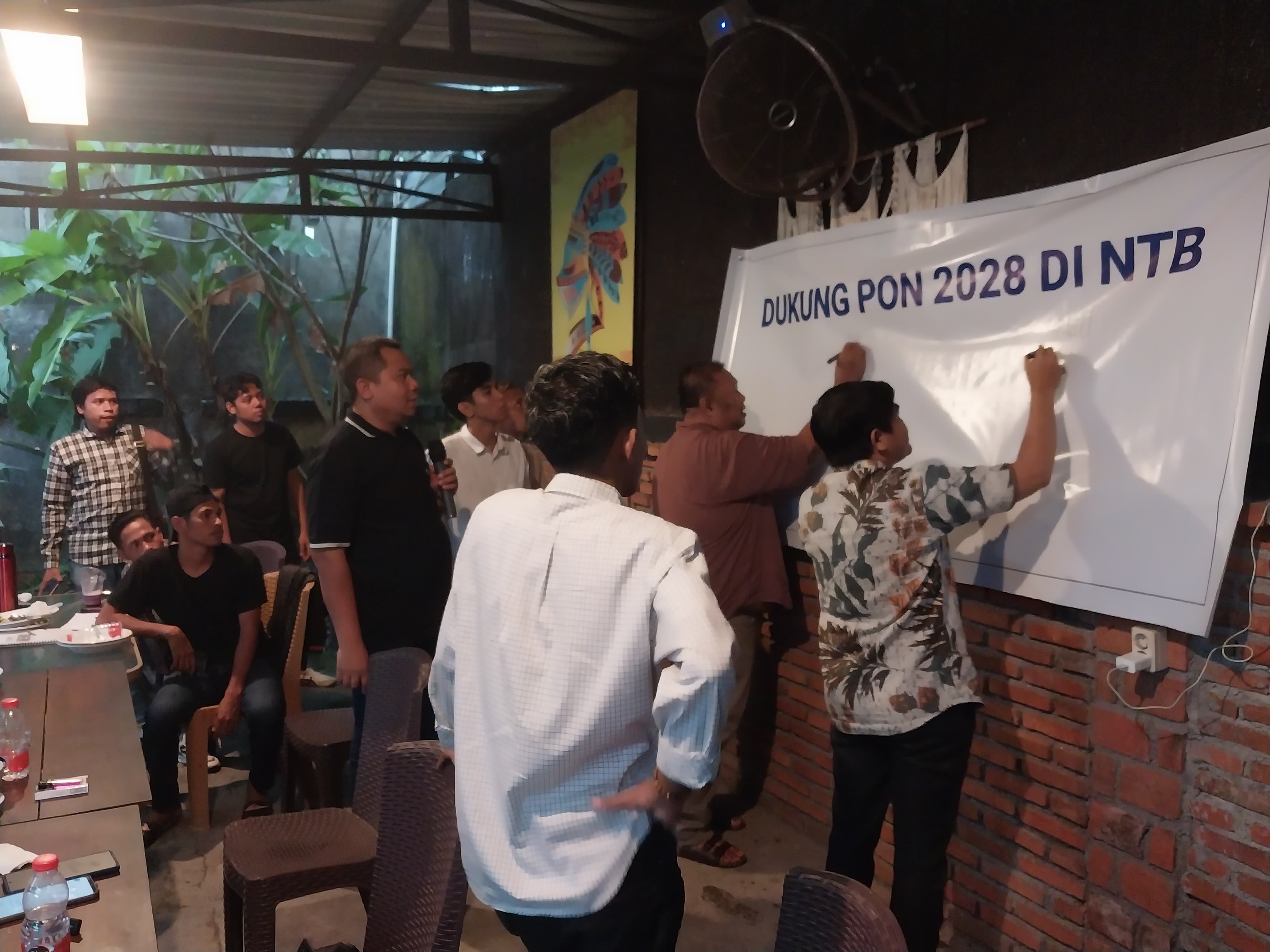 Perwakilan OKP yang tergabung dalam AMS membubuhkan tanda tangan di spanduk sebagai bentuk dukungan kepada NTB untuk menjadi tuan rumah PON XXII 2028 bersama NTT