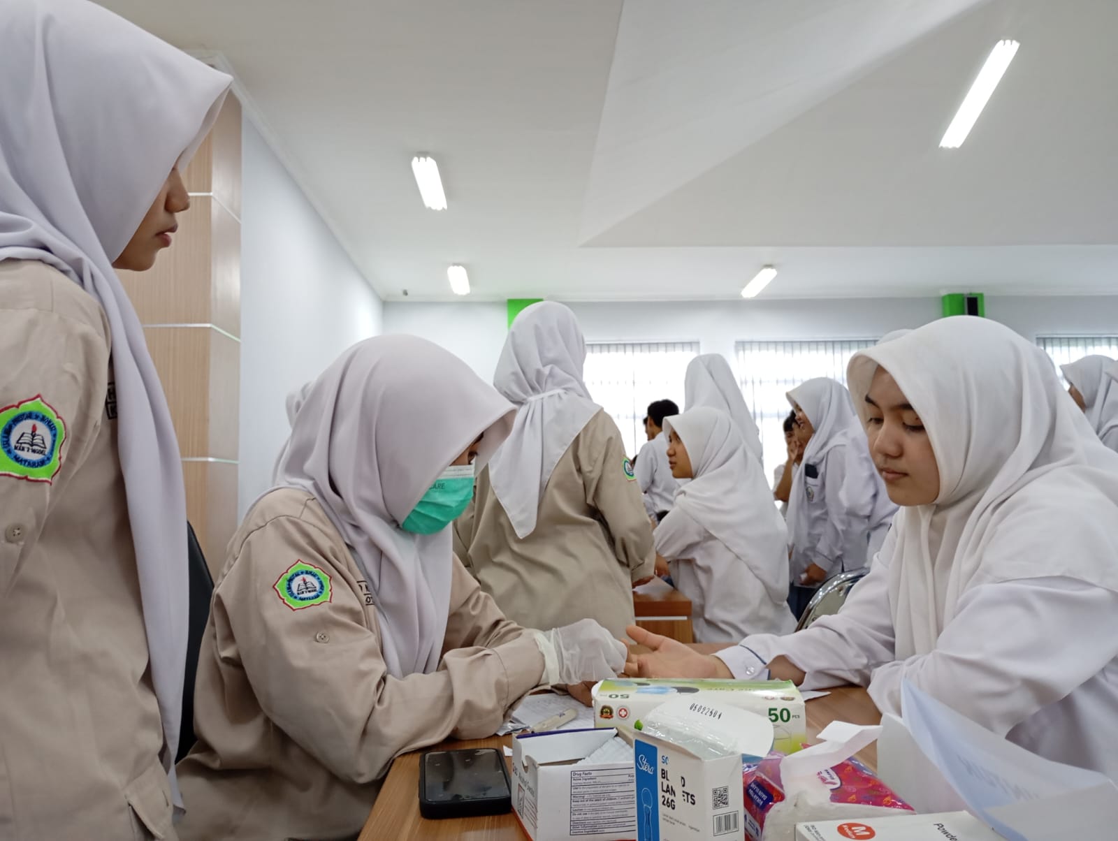 CEK KESEHATAN: Siswa yang tergabung dalam ekskul UKS MAN 2 Mataram mengecek hemaglobin (HB) guru dan siswa &nbsp;di aula madrasah setempat, Senin (5/5).