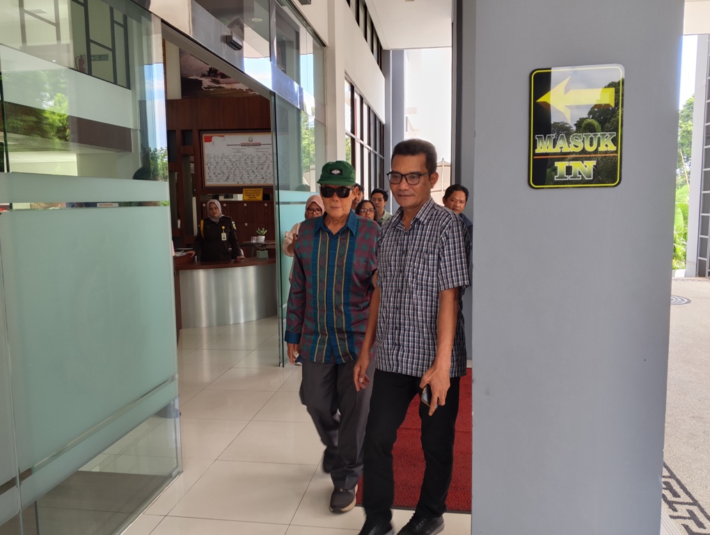 PENUHI PANGGILAN JAKSA: Mantan Bupati Lombok Timur (Lotim) Ali Bin Dachlan (kenakan kacamata hitam) berjalan ke luar lobi kantor Kejati NTB, Selasa (6/5).