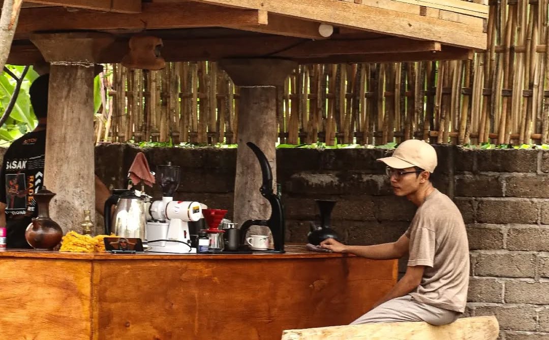NGOPI ASYIK: Salah satu penunjung yang tengah memesan kopi di bar coffee shop Kolanta Coffee di Lombok Utara.