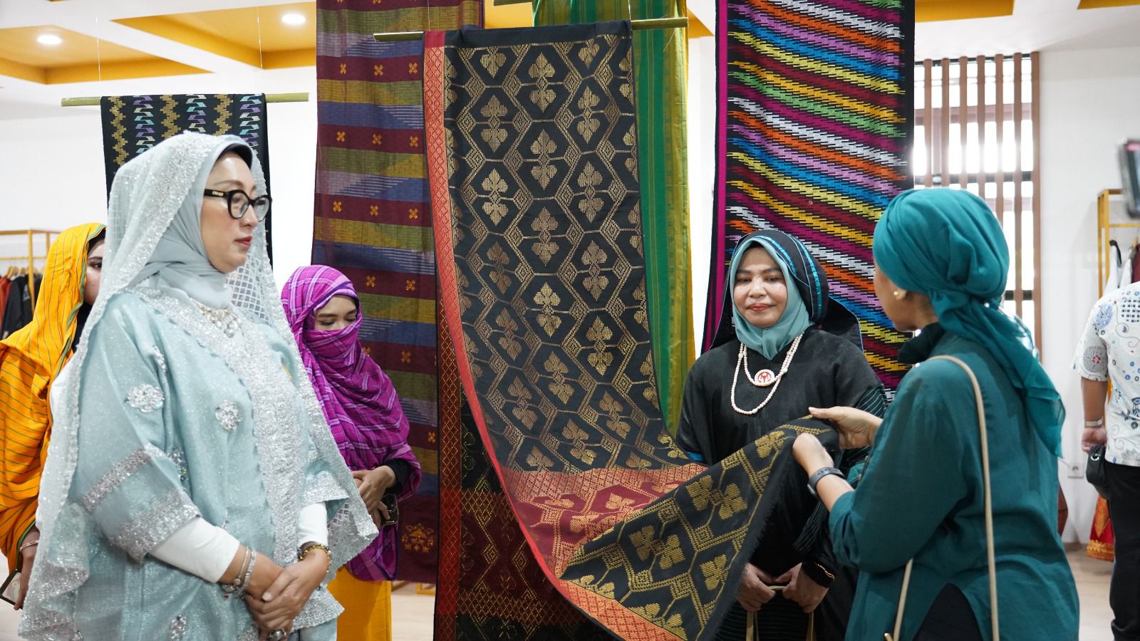 PERKENALKAN TENUN: Ketua Dekranasda NTB Sinta Agathia M Iqbal (kiri) dan Kadisperin NTB Hj Nuryanti memperkenalkan produk tenun kepada delegasi diplomatik yang berkunjung ke NTB Mall, Jumat (9/5).