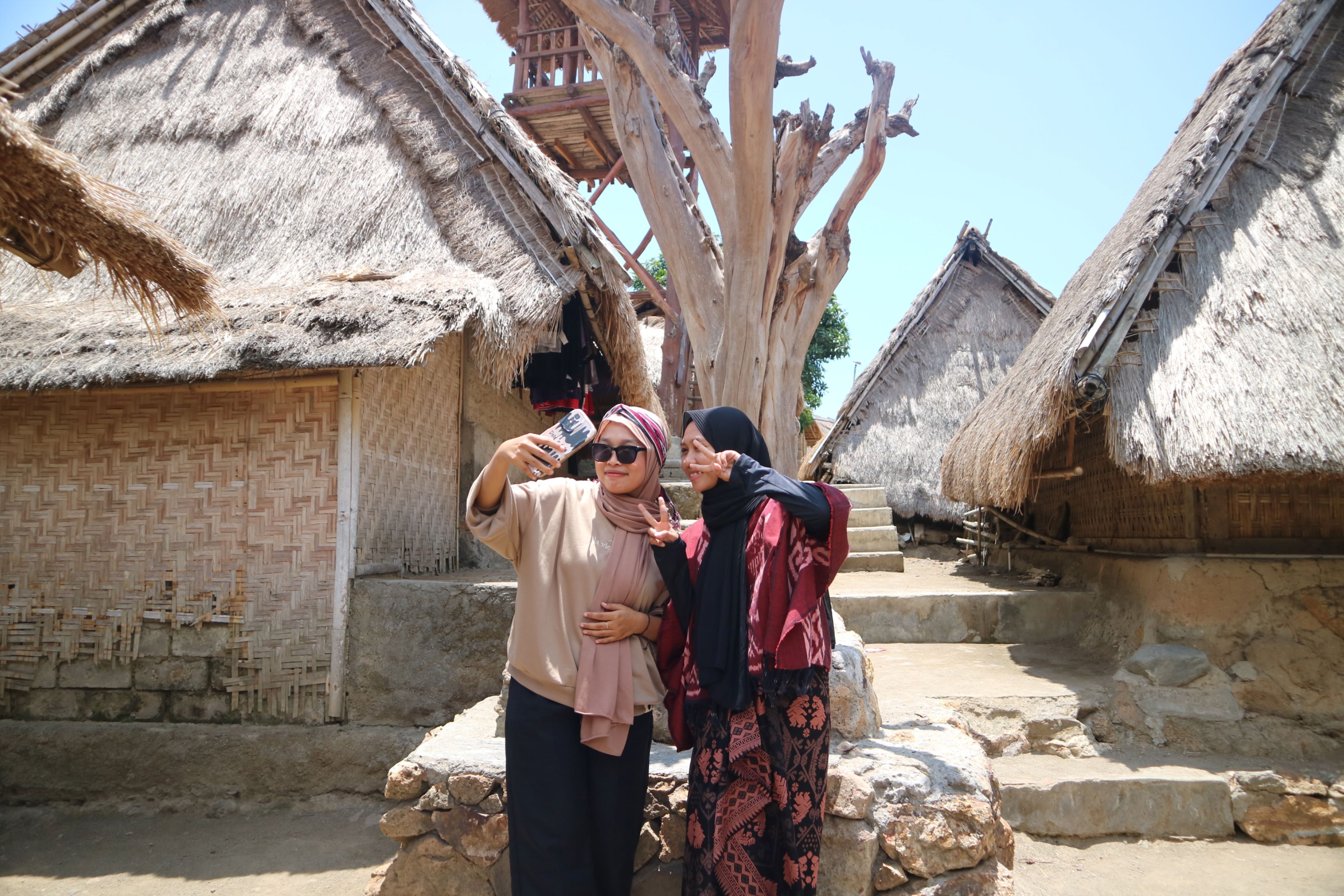Wisatawan domestik berfoto dengan latar Pohon Cinta di Desa Wisata Sade.
