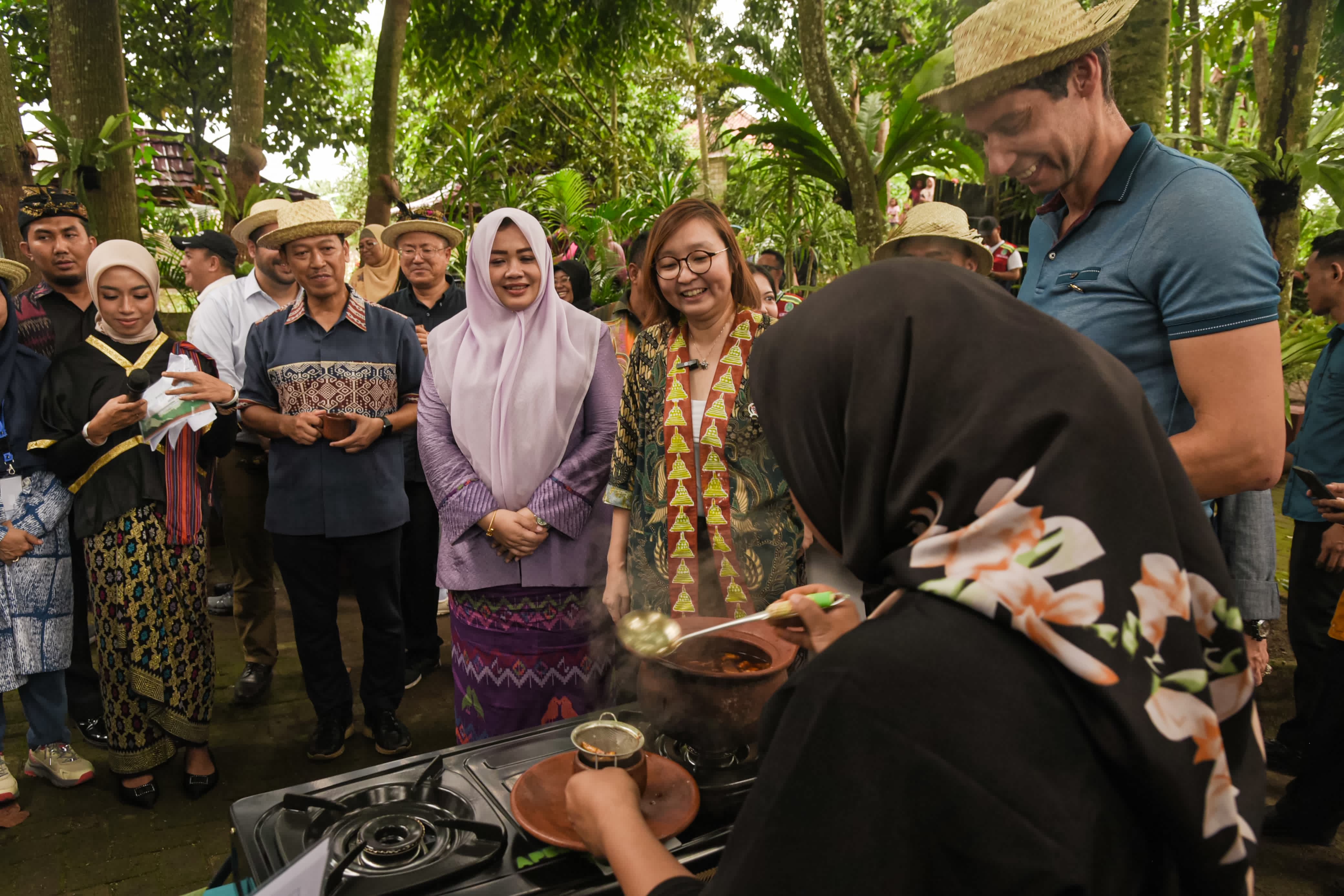 DIPLOMASI KULINER: Seorang diplomat asing ikut demo masak cara membuat jamu tradisional di Desa Wisata Bilebante, Jumat (9/5).