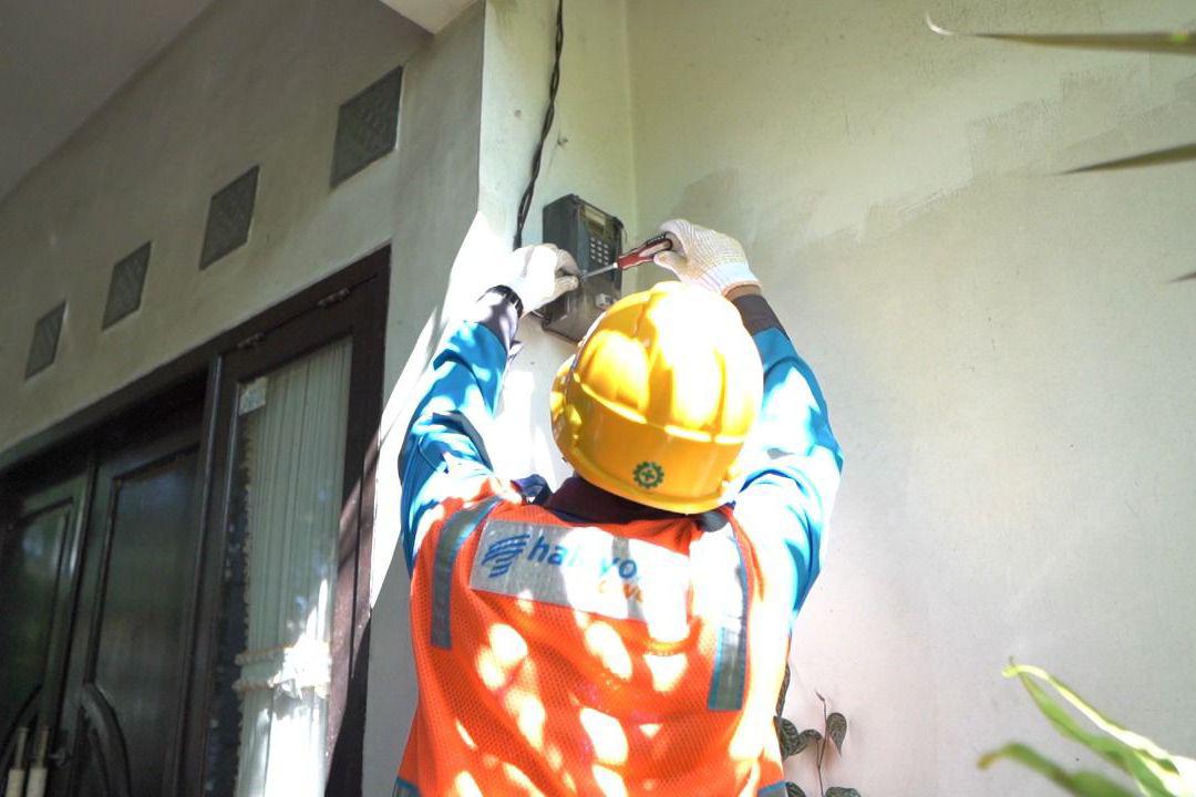 Petugas PLN melakukan tambah daya pada kWH meter pelanggan.