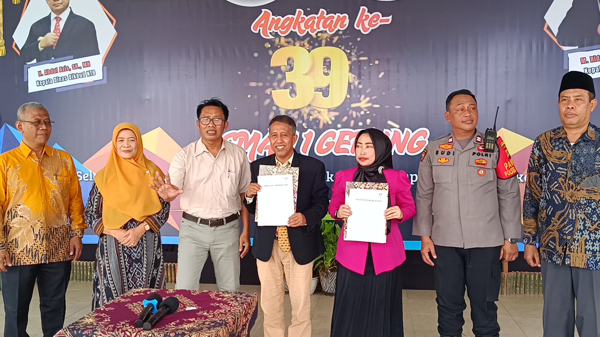 TUNJUKKAN: Kepala SMAN 1 Gerung M Ridwan Helmi (jas hitam) menunjukkan perjanjian kerja sama dengan FK UBG pada pelepasan siswa kelas XII di halaman sekolah setempat, Sabtu lalu (10/5).