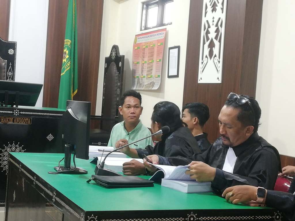 MEMBELA DIRI: Terdakwa Agus Buntung berdiskusi dengan penasihat hukumnya sebelum sidang dimulai di PN Mataram, Rabu (14/5).&nbsp;