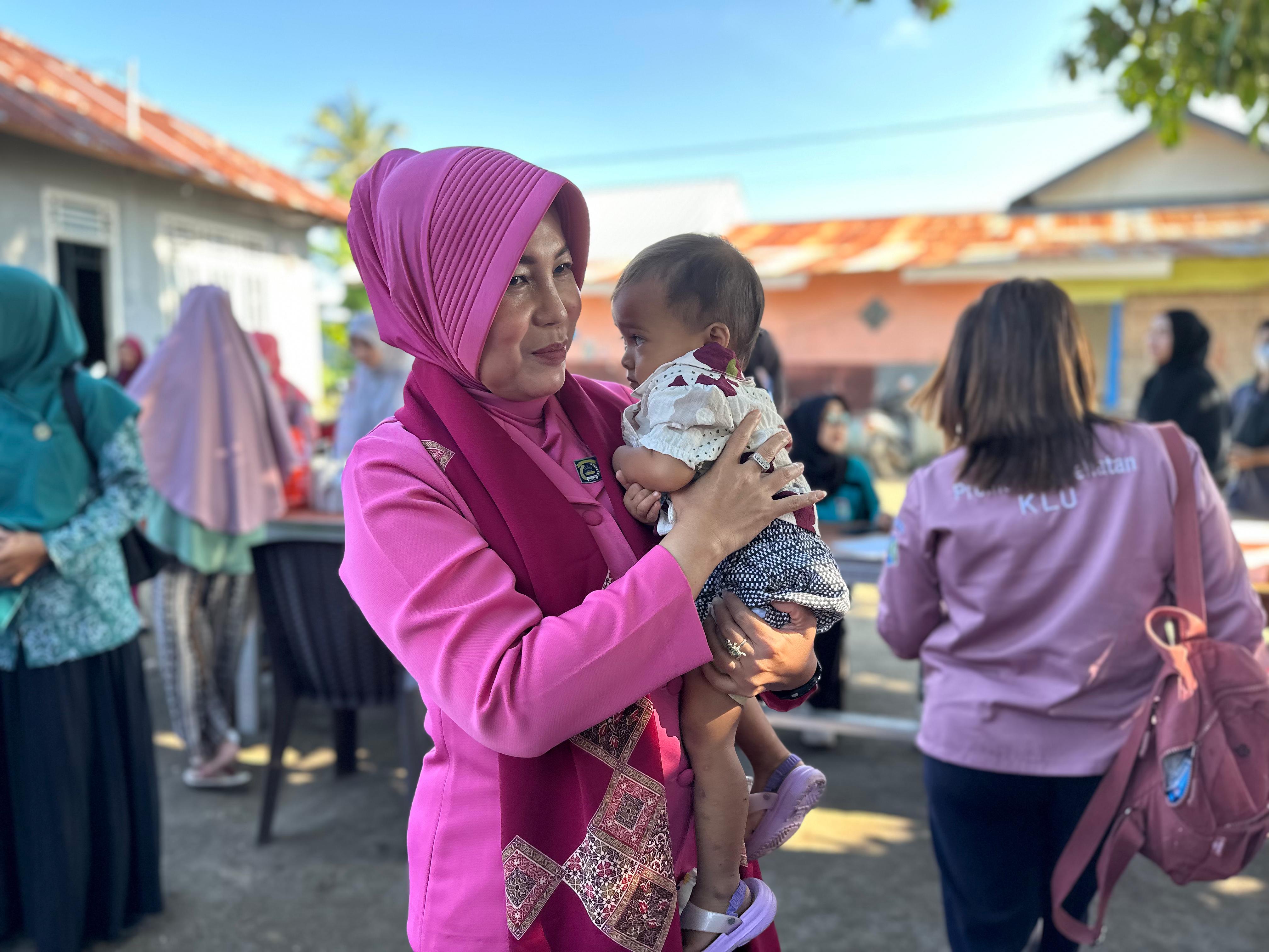 Ketua Bhayangkari Lombok Utara Ny Heny Agus Purwanta menggendong seorang balita saat berkunjung ke posyandu di Desa Sesait, Kecamatan Kayangan, Jumat (16/5).