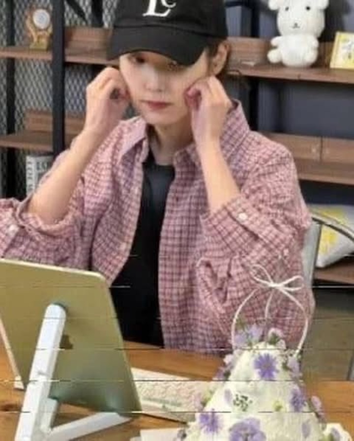 Foto IU saat menggunakan kemeja flanel berwarna sama dengan perempuan yang makan malam bersama V BTS.
