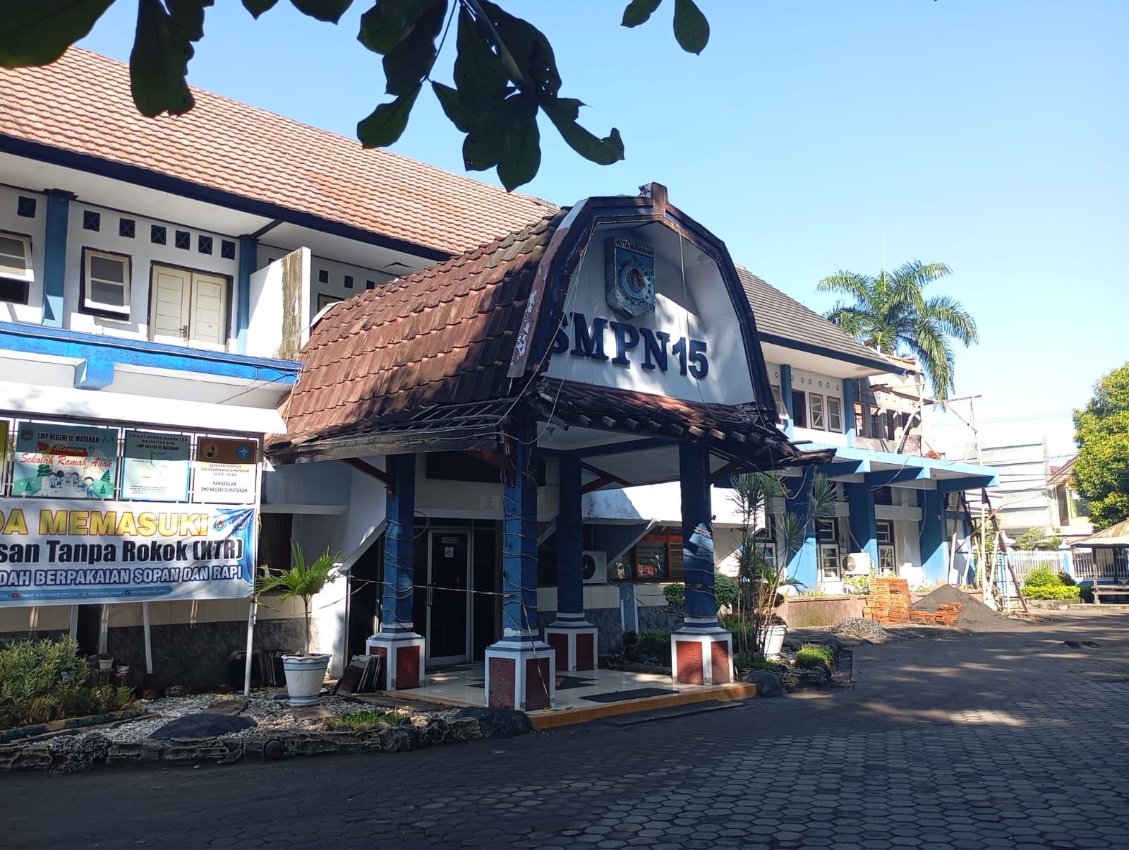 Depan Loby SMPN 15 Mataram dipasangi garis polisi karena ada kerusakan di bagian atas.