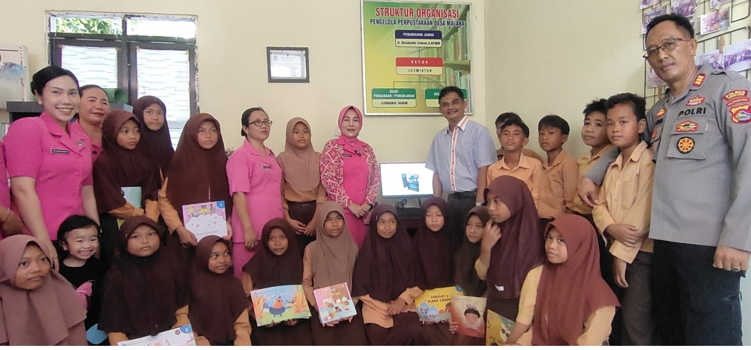 LITERASI: Ketua Bhayangkari Cabang KLU Heny Agus Purwanta bersama anak-anak SD pada peringatan Hari Buku Nasional di Desa Malaka, Kecamatan Pemenang