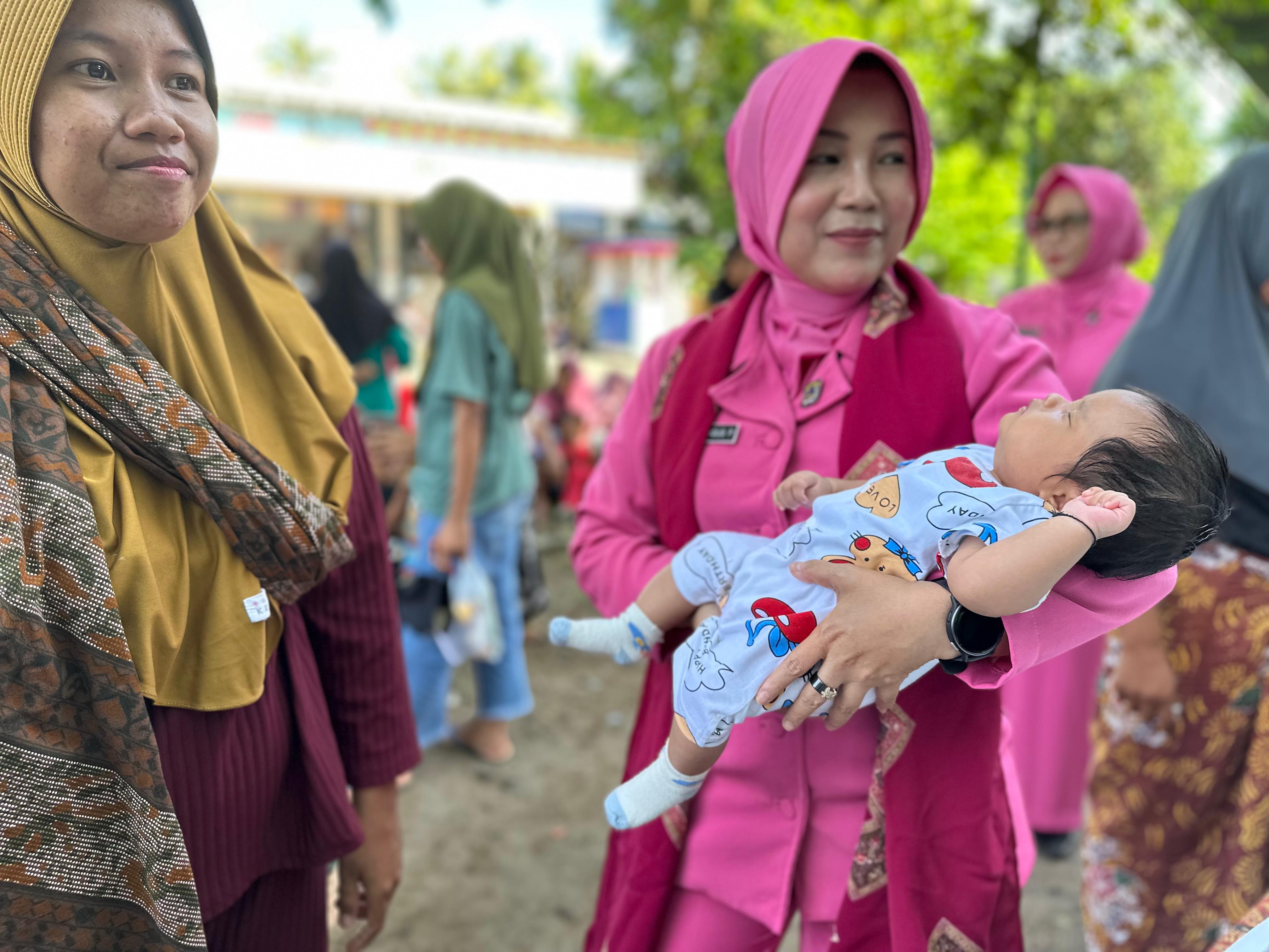 Ketua Bhayangkari Cabang Lombok Utara mengendong bayi saat mengunjungi Posyandu Karang Krakas, Dusun Boyotan, Desa Gumantar, Kecamatan Kayangan