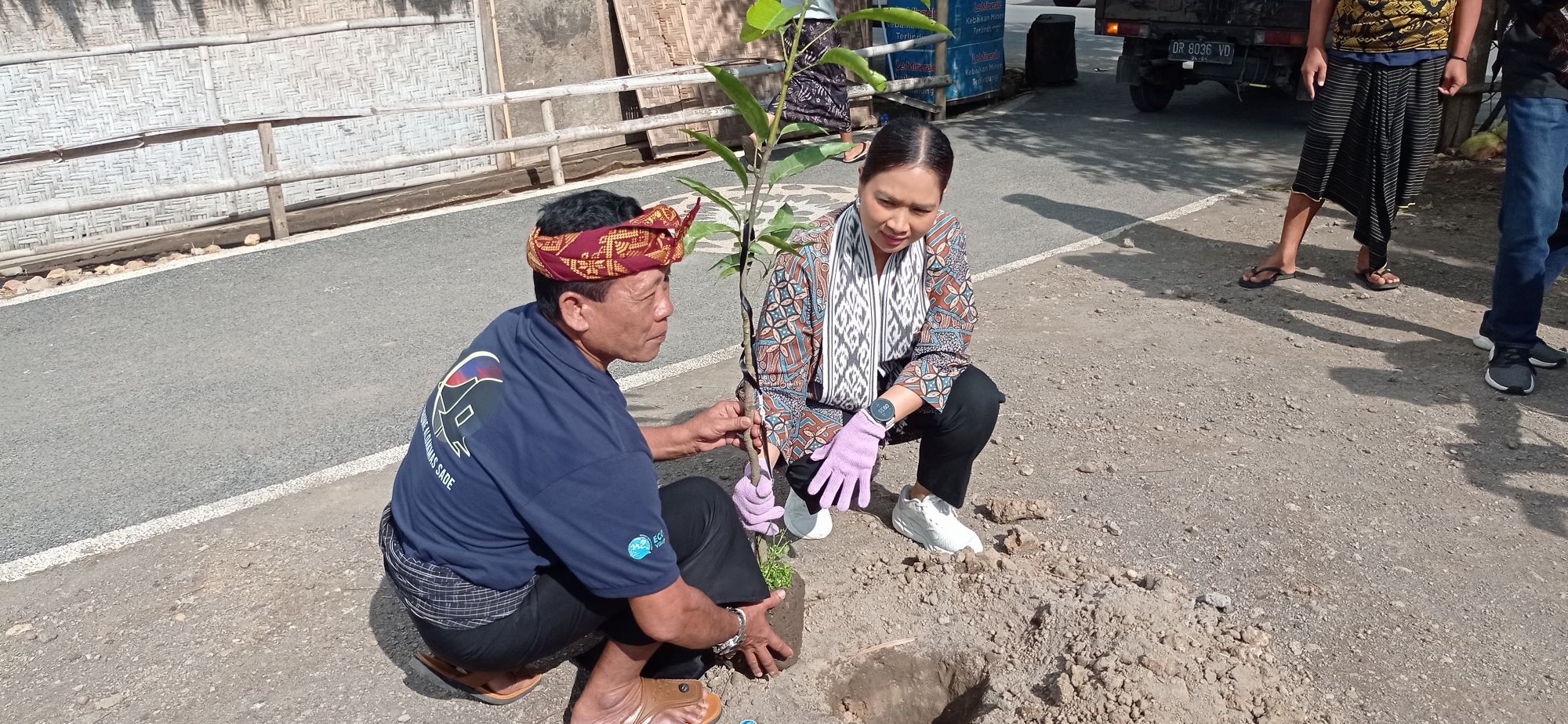 Wamenpar Ni Luh Enik Ermawati menanam pohon setelah launching program Eco Village yang diinisiasi Otsuka di Desa Adat Sade.