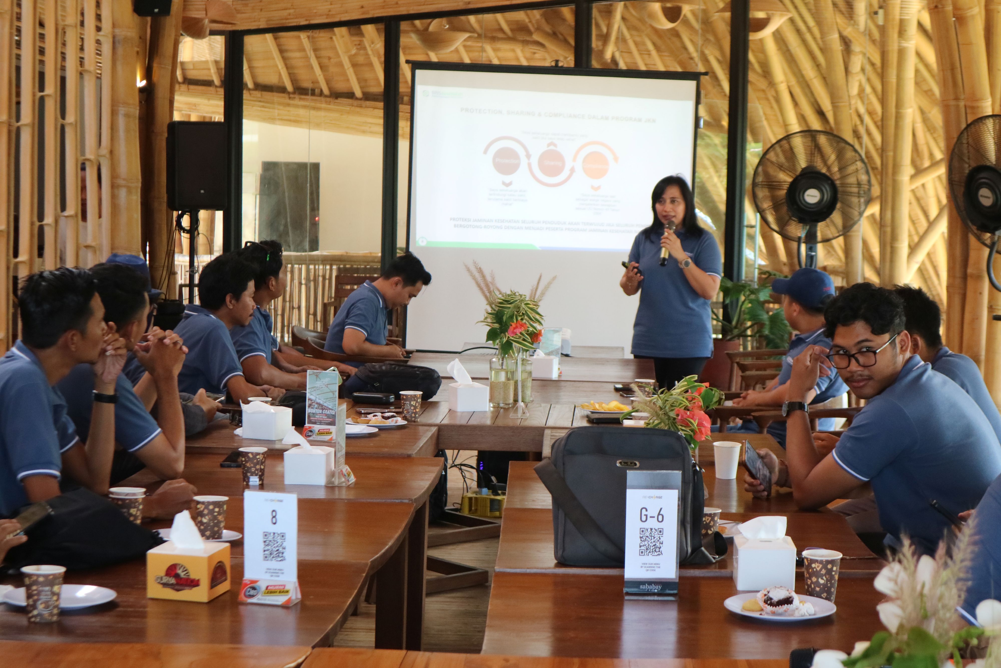 SOSIALISASI: Kepala BPJS Kesehatan Cabang Selong Elli Widiani (berdiri) berikan penjelasan mengenai program-program BPJS Kesehatan di salah satu kafe, Kuta, Pujut, Loteng, Jumat (23/5).