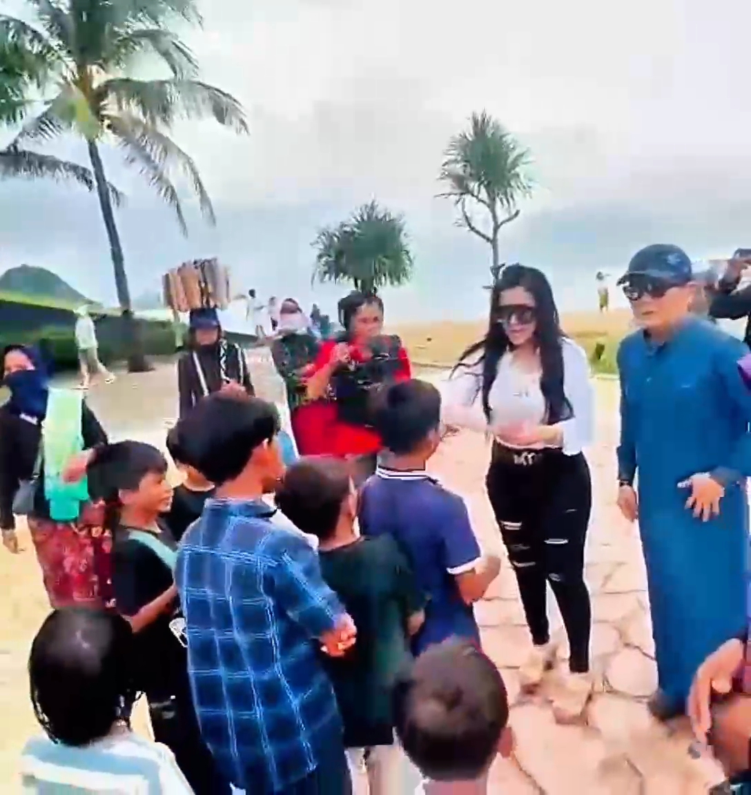 BERBAGI: Andre Yakub selaku rekan bisnis Sudin sekaligus investor bersama Barbie Kumalasari bagi-bagi duit kepada pedagang asongan di Pantai Kuta Mandalika, Lombok Tengah, Minggu (25/5) sore.