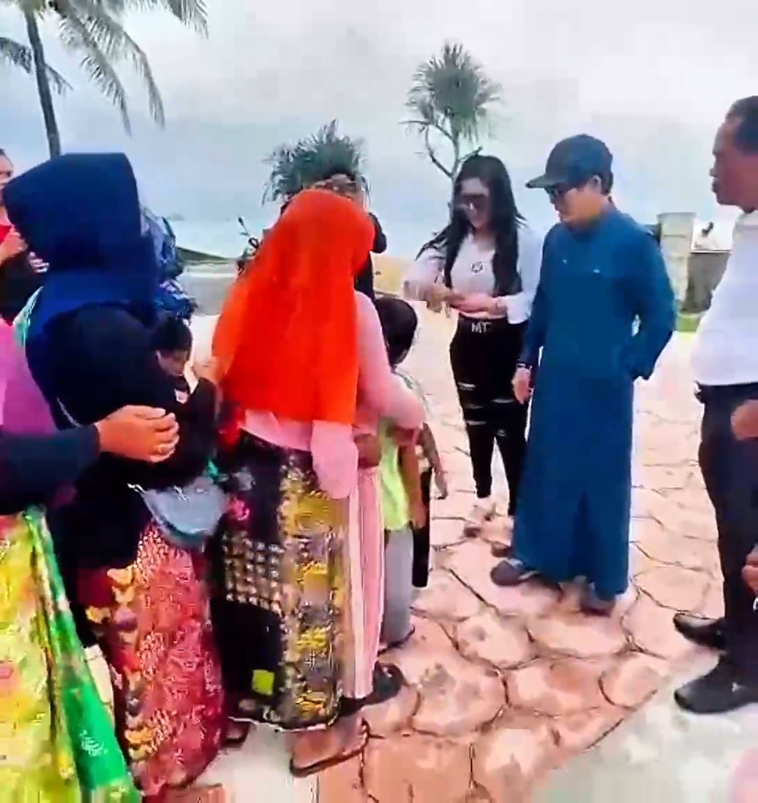 BERBAGI: Andre Yakub selaku rekan bisnis Sudin sekaligus investor bersama Barbie Kumalasari bagi-bagi duit kepada pedagang asongan di Pantai Kuta Mandalika, Lombok Tengah, Minggu (25/5) sore.