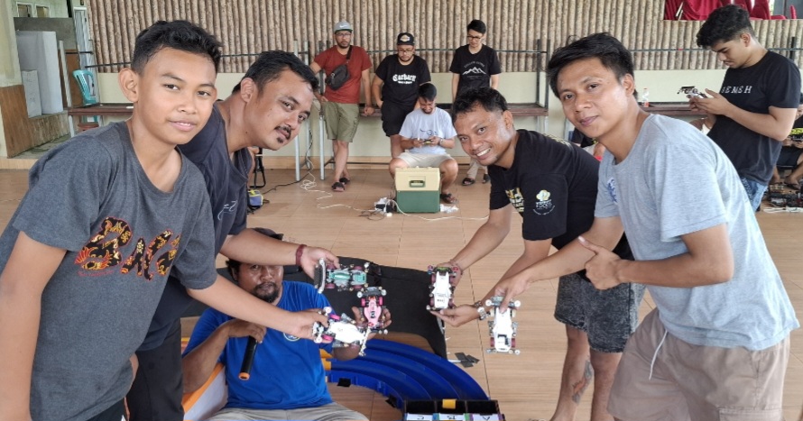 SERU-SERUAN: Ketua Lombok Tamiya Community Mohammad Fitrayadi (dua dari kiri) dan racer lainnya menunjukkan mobil Tamiya saat kompetisi di Sayang-Sayang, Mataram, Senin (19/5).