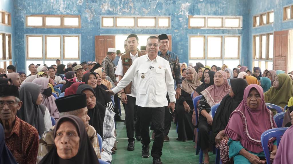 MENYAPA WARGA: Wali Kota Bima HA Rahman H Abidin saat menghadiri acara pendistribusian zakat konsumtif bagi fakir miskin bersama Baznas Kota Bima di Aula Kantor Camat Asakota.