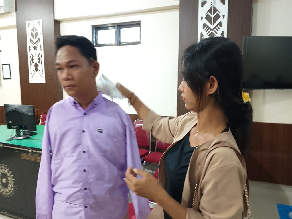 PASANGAN SETIA: Istri terdakwa pelecehan seksual mengusap dahi terdakwa Agus Buntung sebelum sidang pembacaan putusan di PN Mataram, Selasa (27/5).