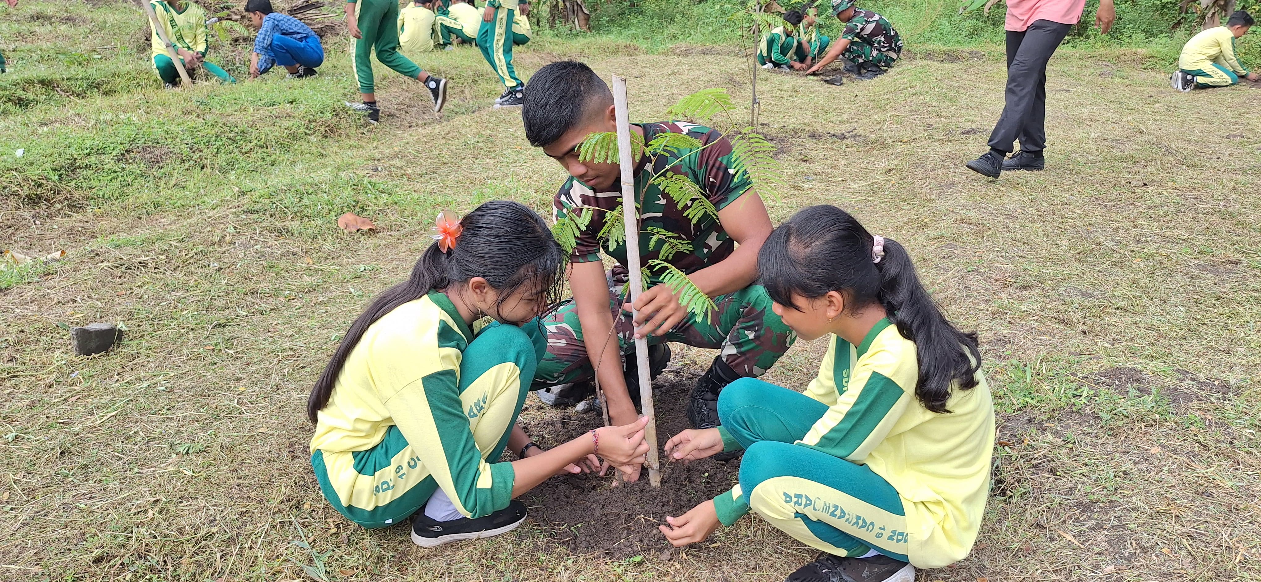 Murid SDN 19 Cakranegara bersama TNI AD menanam pohon buah di sekitar Lapangan Yonif 742/SWY.