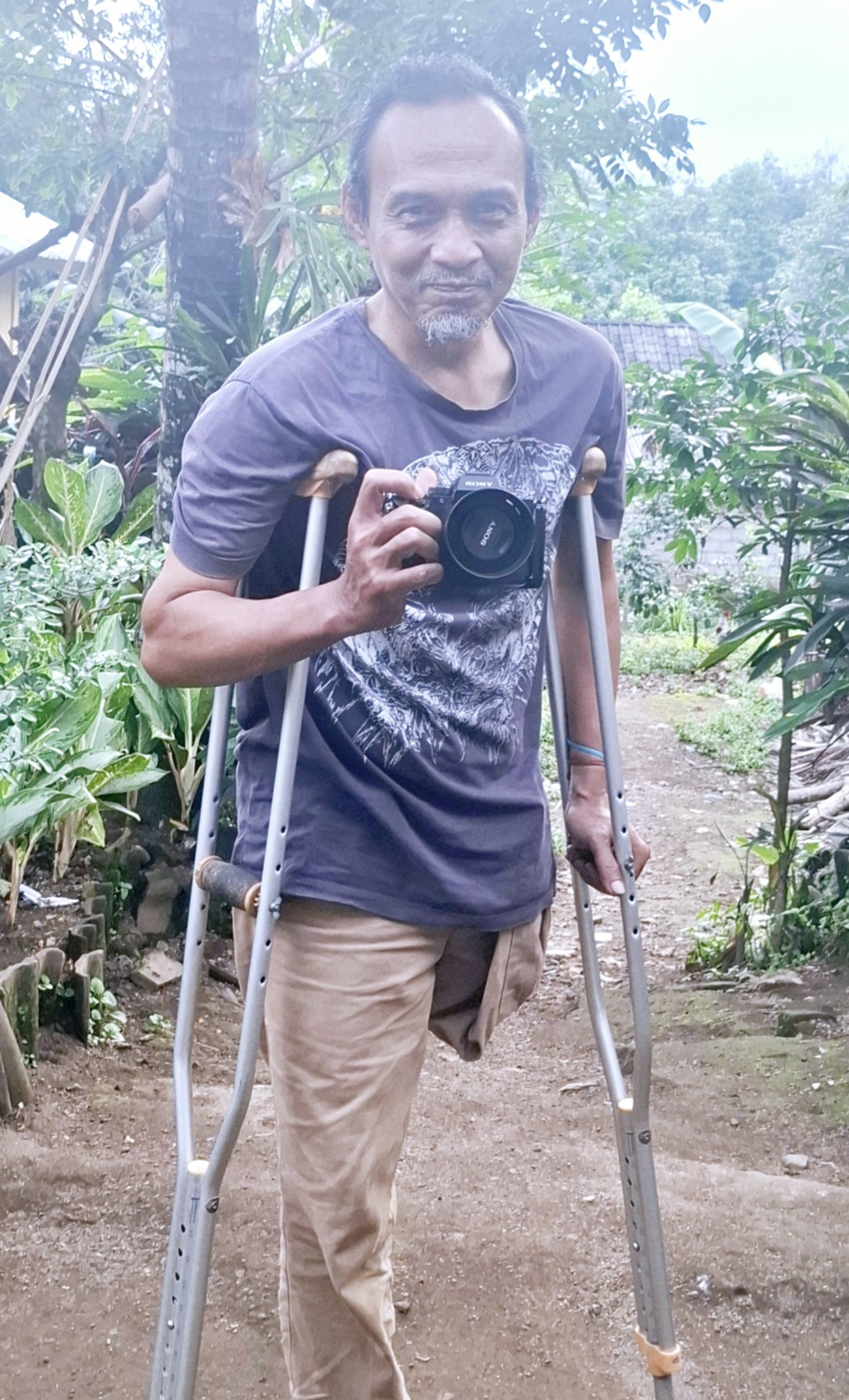 UMAR/LOMBOK POST  PROFESIONAL: Suhendra Harianto adalah seorang fotografer difabel asal Mantang, Kecamatan Batukliang, Lombok Tengah. Dia rajin hunting foto meski dalam keterbatasan kondisi fisik.