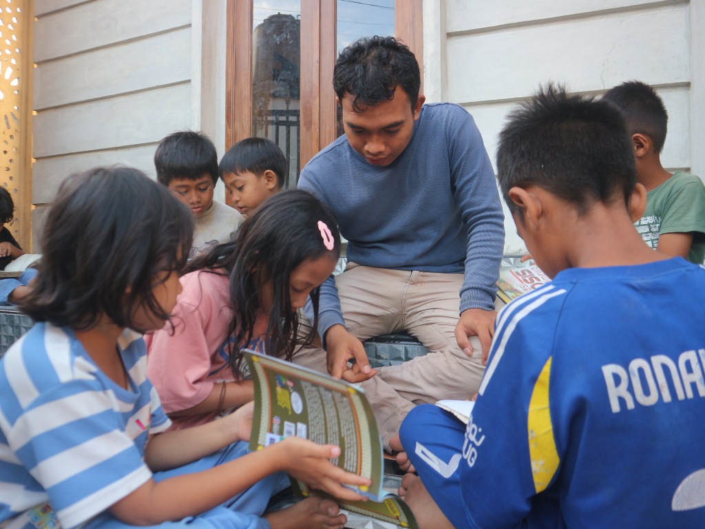 MEMBACA: Anak-anak di Dusun Perenang Desa Kabar, Kecamatan Sakra saat membaca buku di teras musala pada acara pojok baca yang diselenggarakan Ikatan Pemuda Dusun Perenang (IPDP), Minggu (1/6).