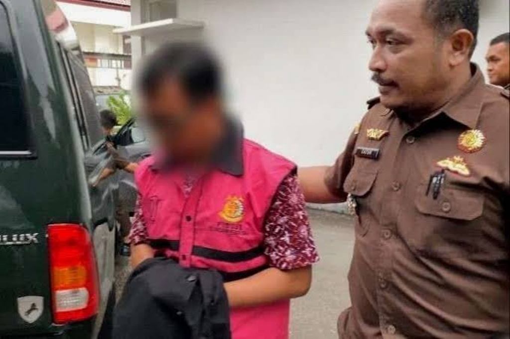 DIBAWA KE MOBIL TAHANAN: Terdakwa korupsi dana BOS SMAN 1 Woha dibawa oleh Kasi Pidsus Kejari Bima Catur Hidayat menuju mobil tahanan, belum lama ini.