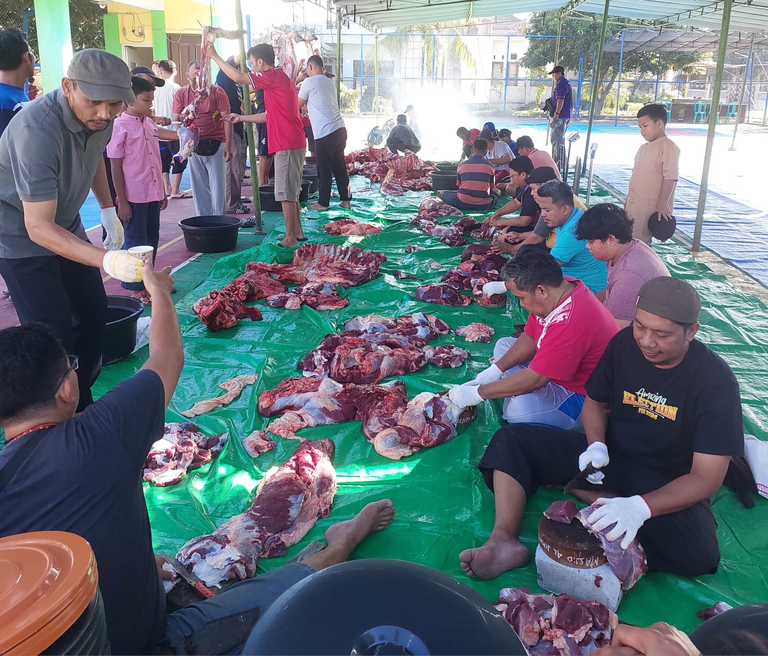 Warga Lingkar Pratama Pagutan Mataram bergotong royong memotong daging kurban.