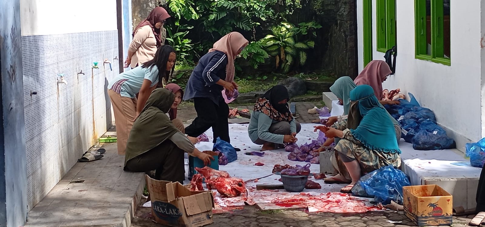Para guru dan staf SMPN 3 Mataram memotong daging kurban di sekolah setempat.
