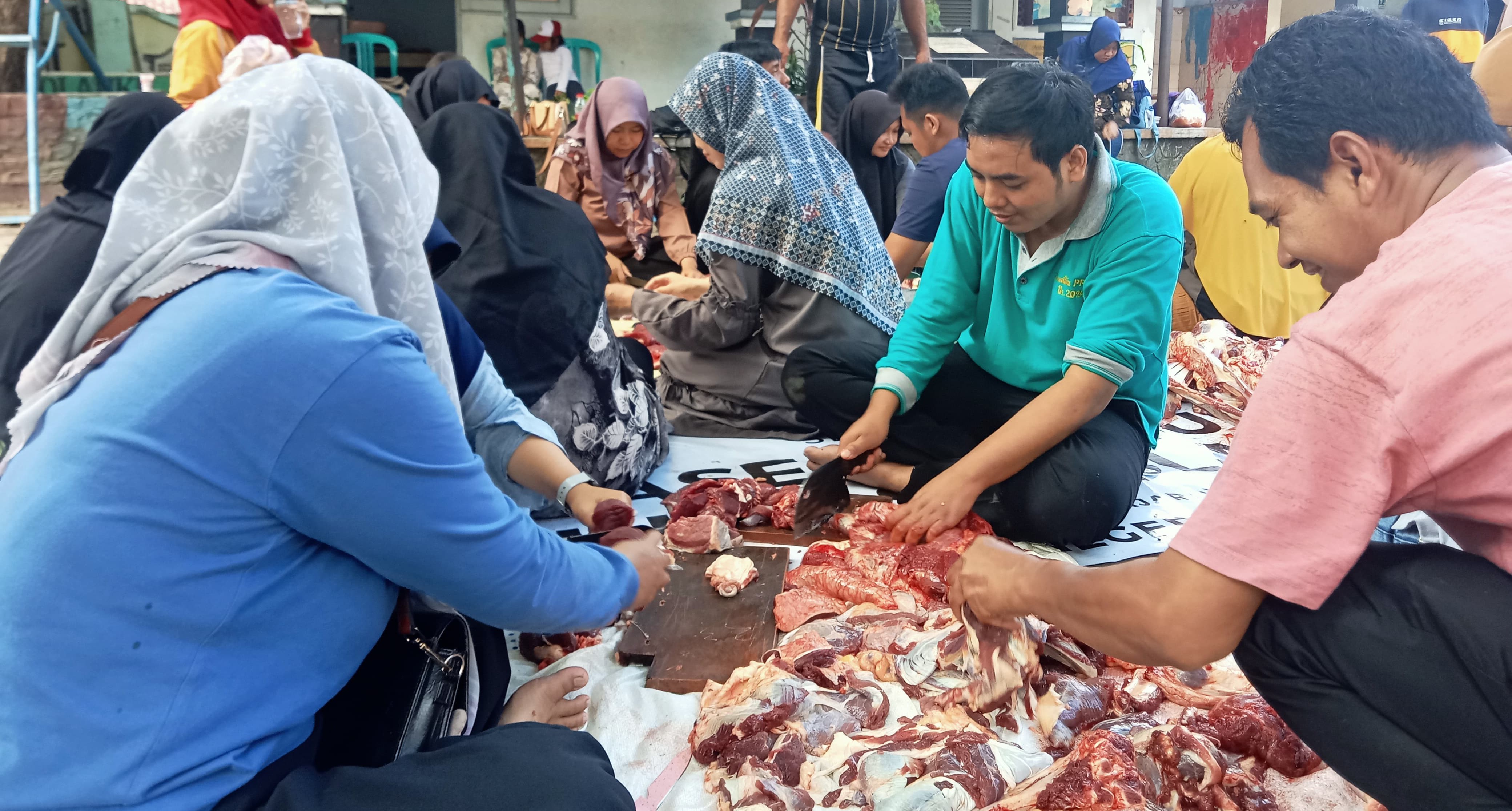 Para guru SDN 1 Ampenan memotong daging kurban di halaman sekolah setempat.