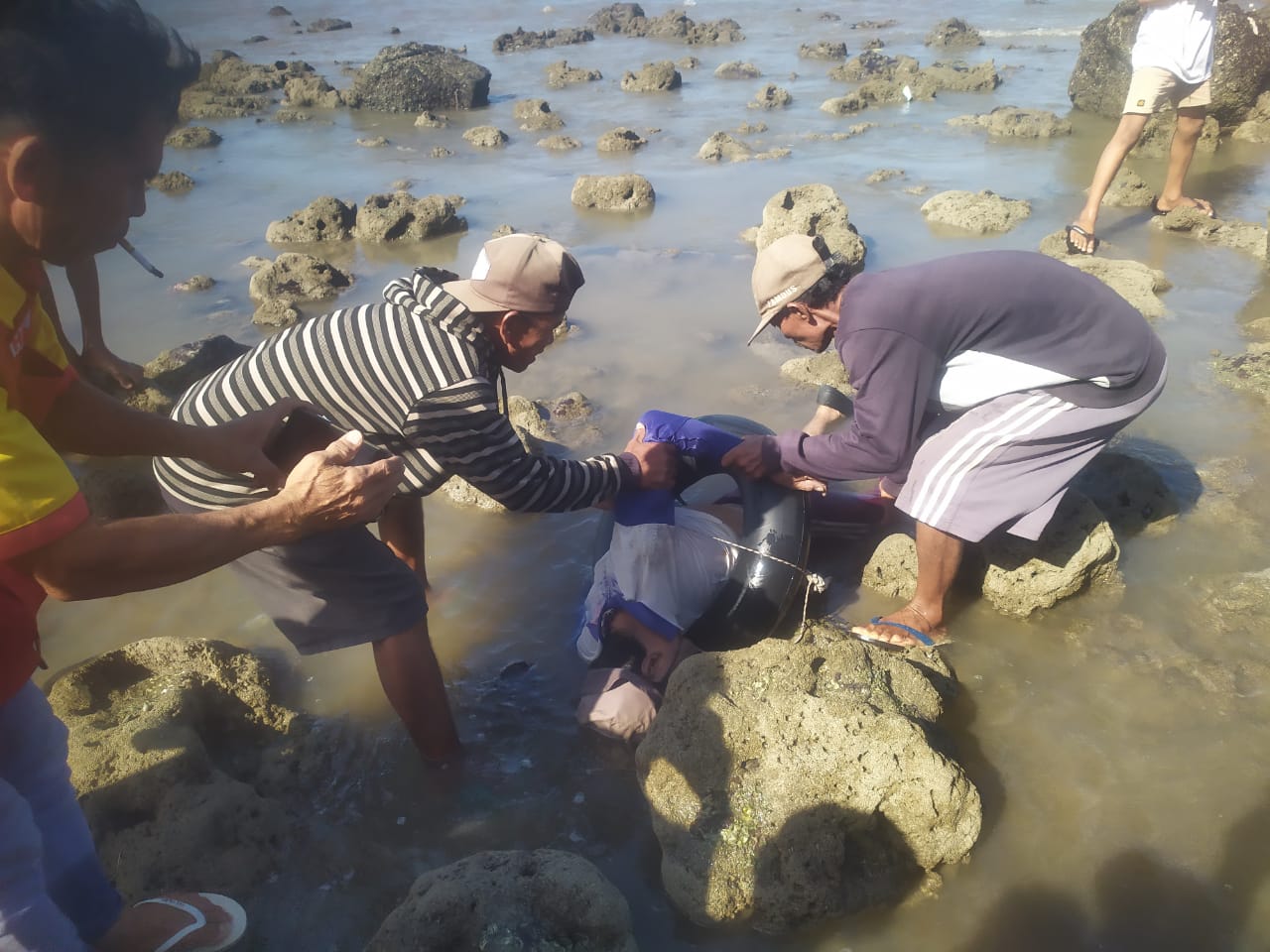 Seorang warga tengah mengevakuasi mayat laki-laki yang ditemukan di pantai Rambang, Desa Surabaya, Kecamatan Sakra Timur, Selasa (10/6). (Humas Polres untuk Lombok Post)