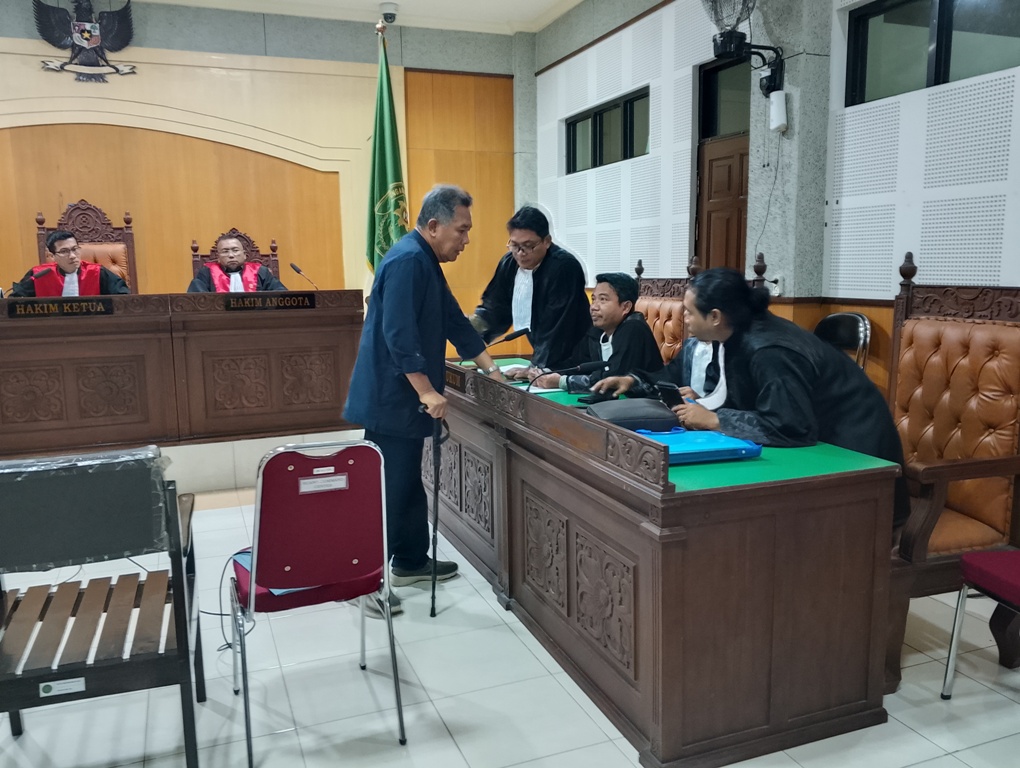 SIDANG PERDANA: Terdakwa Zaini Arony berkonsultasi dengan penasihat hukumnya usai sidang di Pengadilan Tipikor Mataram, Selasa (10/6).