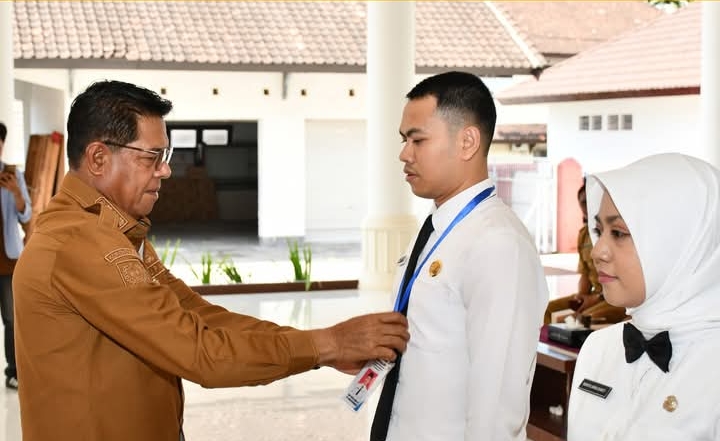 Bupati Lombok Timur H Haerul Warisin saat memasangkan kartu tanda pengenal kepada peserta pelatihan Latsar.