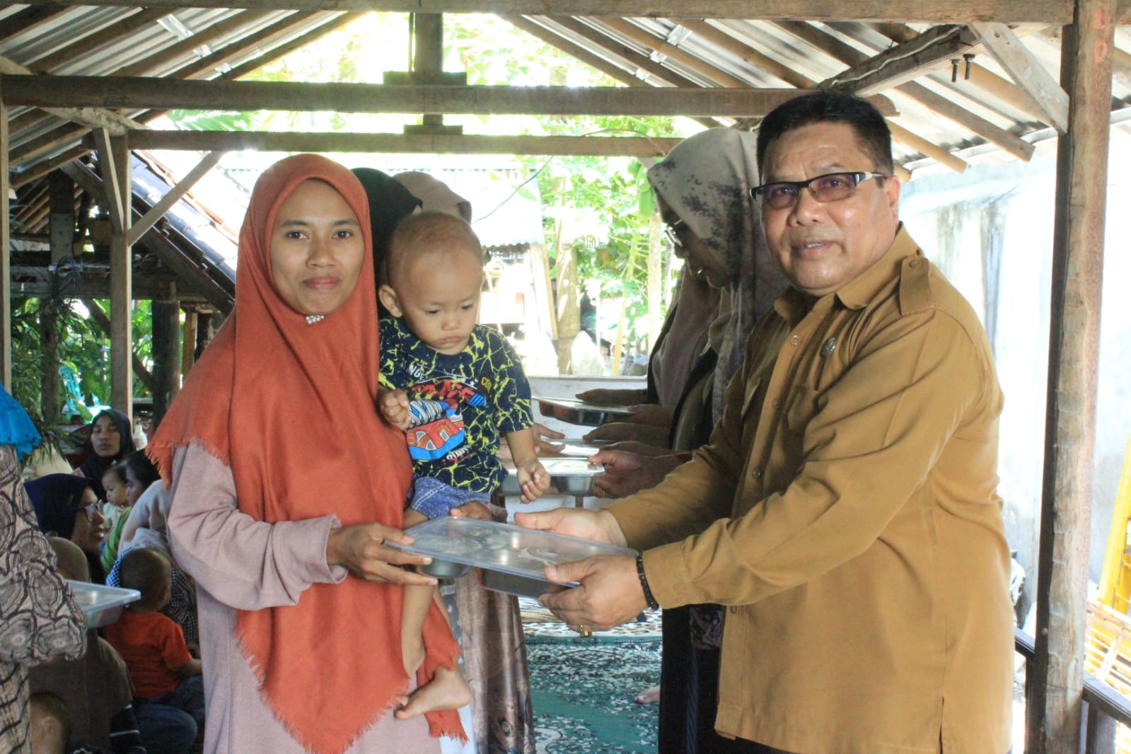 SERAHKAN: Kepala Dinas Pemberdayaan Perempuan Perlindungan Anak dan Keluarga Berencana (DP3AKB) Lombok Timur H Ahmat saat membagikan makanan bergizi gratis (MBG) untuk ibu hamil di Kecamatan Selong.