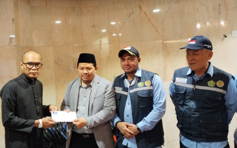 Chief Operating Officer BPKH Limited, Iman Ni&rsquo;matullah memberikan dana kompensasi secara simbolis kepada jemaah yang tidak mendapat makanan, Kamis, 12 Juni 2025.