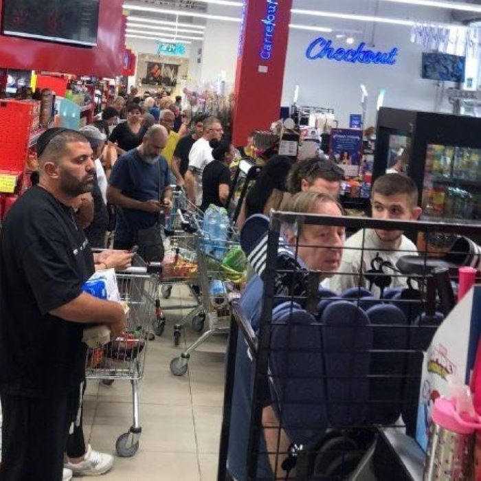 Warga menyerbu rak makanan dan air minum di supermarket di tengah kekhawatiran serangan balasan dari Iran. (Foto: AFP/Getty Images)