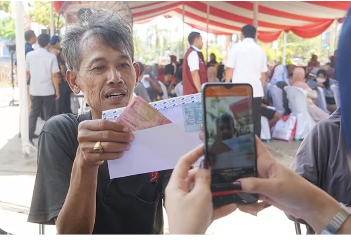 Seorang warga memperlihatkan bantuan BLT El Nino yang diterima dari kantor pos.