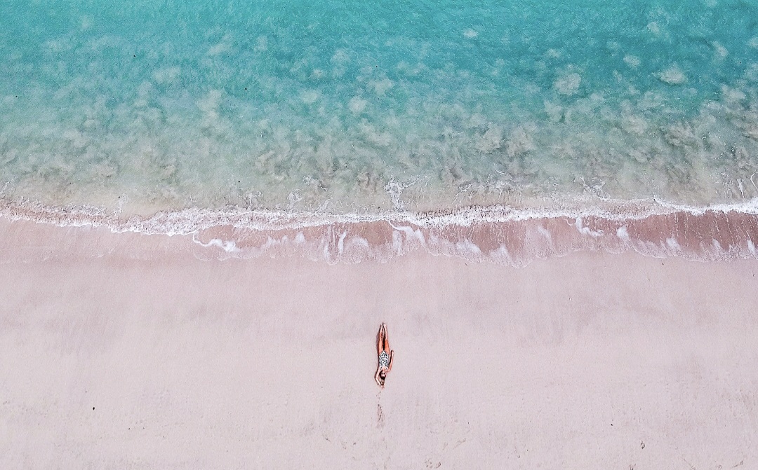 MEMIKAT WISATAWAN: Wisatawan asing menikmati pantai sambil berjemur di Pantai Pink, Lombok Timur. Pariwisata jadi andalan Pemprov NTB dalam mengentaskan kemiskinan ekstrem.