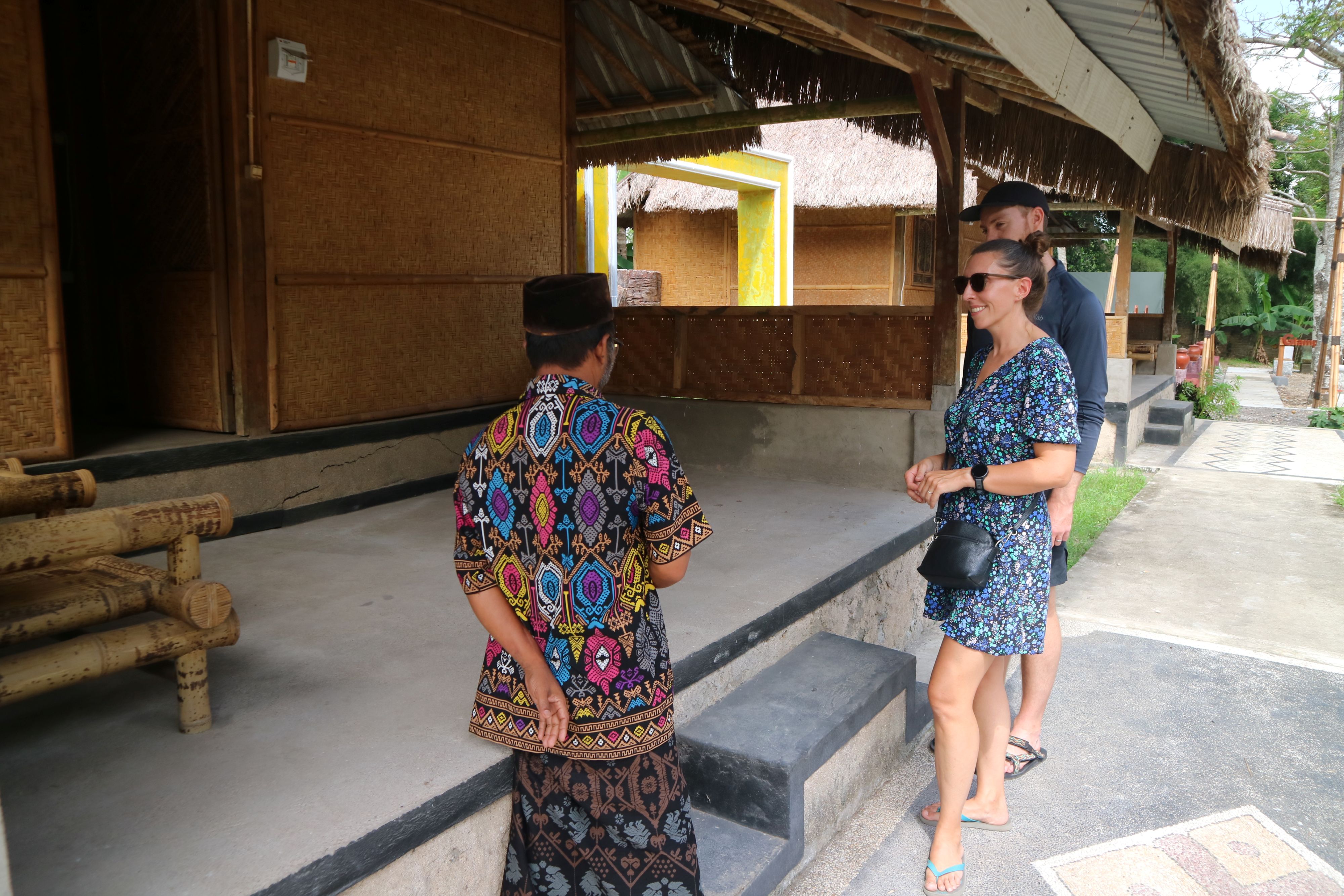 Seorang pemandu berikan penjelasan soal rumah adat kepada sepasang turis saat berkunjung ke Museum Tenun Dharma Satya di Desa Puyung, Kecamatan Jonggat, Loteng, Kamis (12/6).