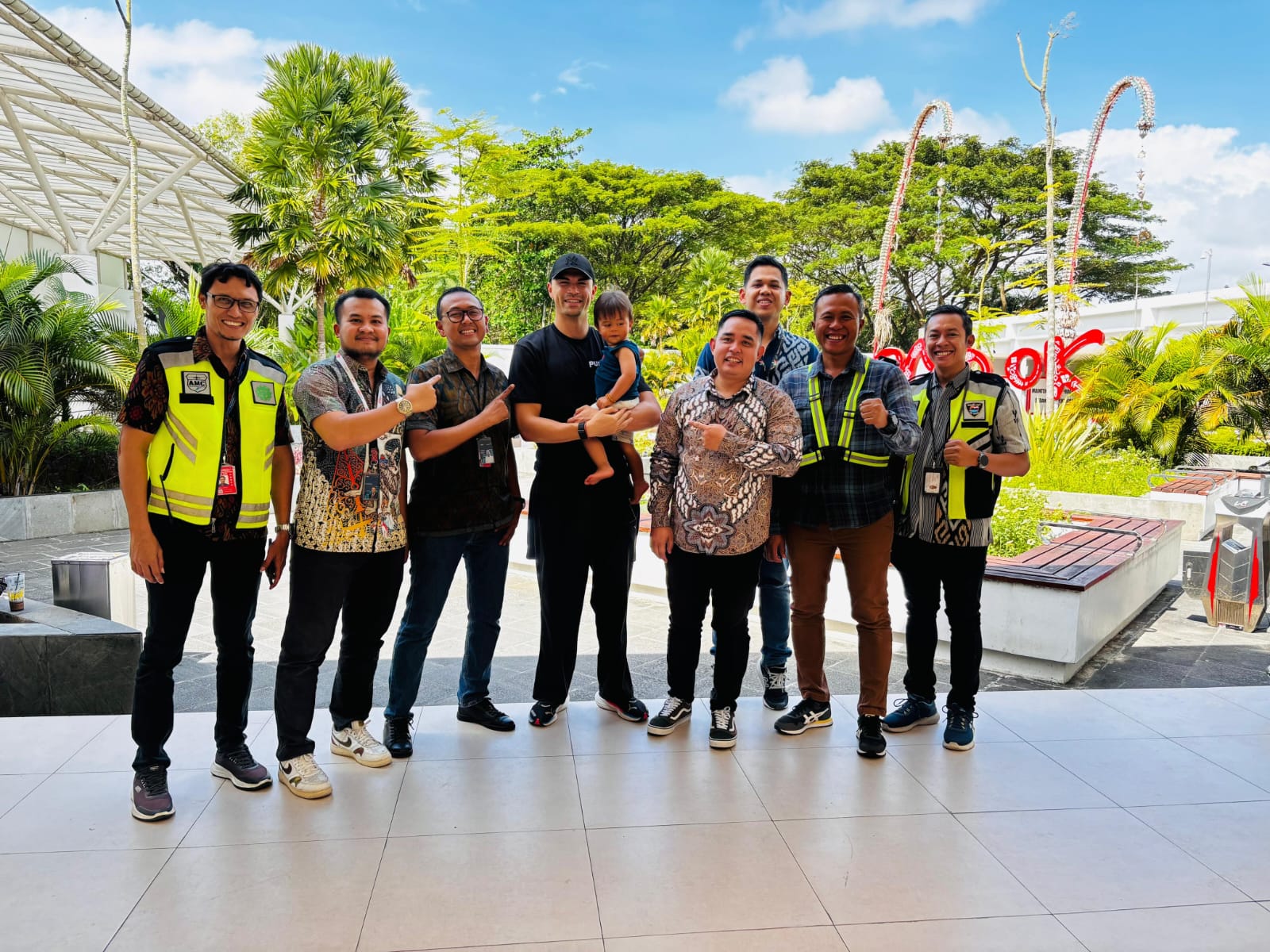 Penjaga gawang Timnas Indonesia Emil Audero Mulyadi (Paling tengah) menggendong sang anak saat berfoto bersama jajaran PT Angkasa Pura Indonesia Kantor Cabang Bandara Lombok usai tiba di bandara.